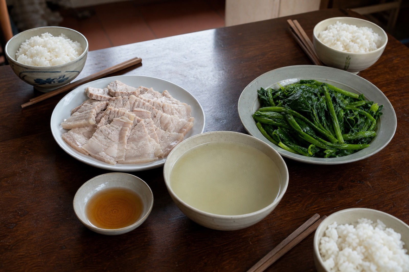 越南家庭餐桌上的水煮豬肉、水煮青菜、菜湯、魚露與白飯示意圖